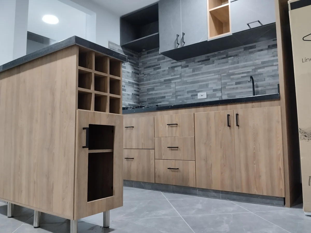 Cocina integral moderna con isla y botellero en melamina en Medellín