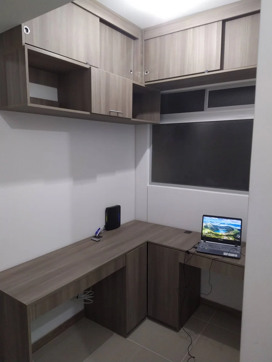 Estudio en L con alacenas corredizas en melamina